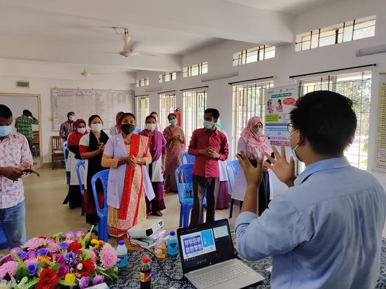 Nurses and health workers standing and practising a handwashing sequence together