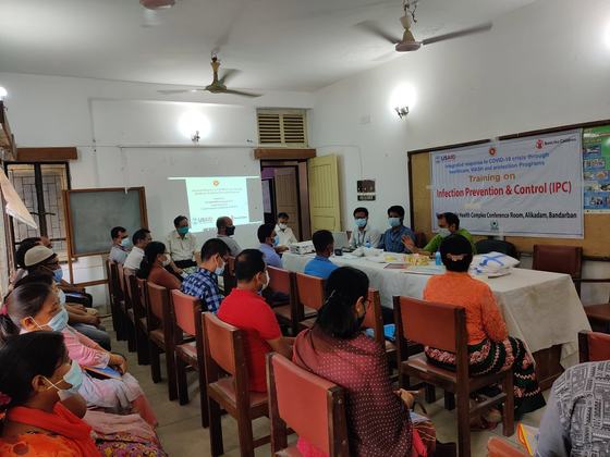 A conference room of masked participants at the opening of an infection prevention and control training