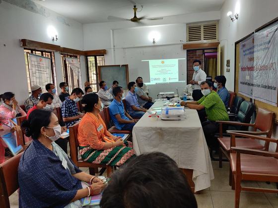 Participants taking notes while the programme objectives are projected on screen