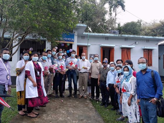 A large group of health staff and ICRC delegates standing together outside the Union Health and Family Welfare Centre