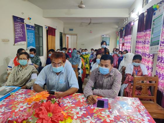 A room of masked health and family planning staff seated in rows for a coordination meeting